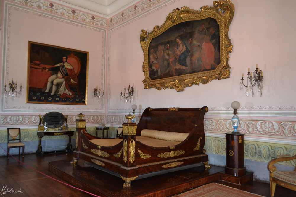 Quarto da Sua Majestade- à esquerda pintura de D. João VI e em cima da cama, da Sagrada Família.